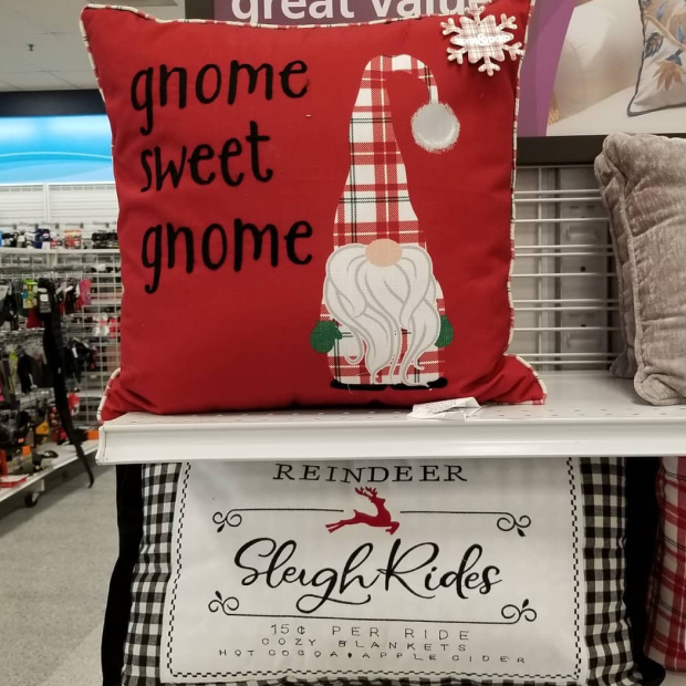 Two pillows are shown on a store shelf with messages "gnome sweet gnome" and "Reindeer Sled Rides"