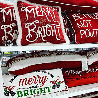 Variety of Christmas décor pillows seen on store shelf