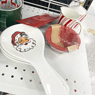 An image displaying adorable red and white glazed Santa Claus Christmas spoon rests, small dishes, and Christmas mugs from a Ross store