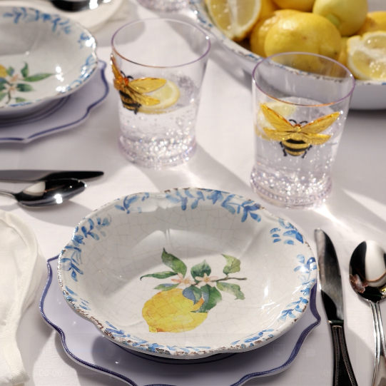 Lemon patterned bowl with utensils and cups.