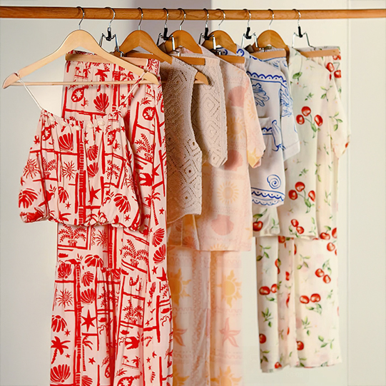 Summer ladies' dresses on a wooden rack.